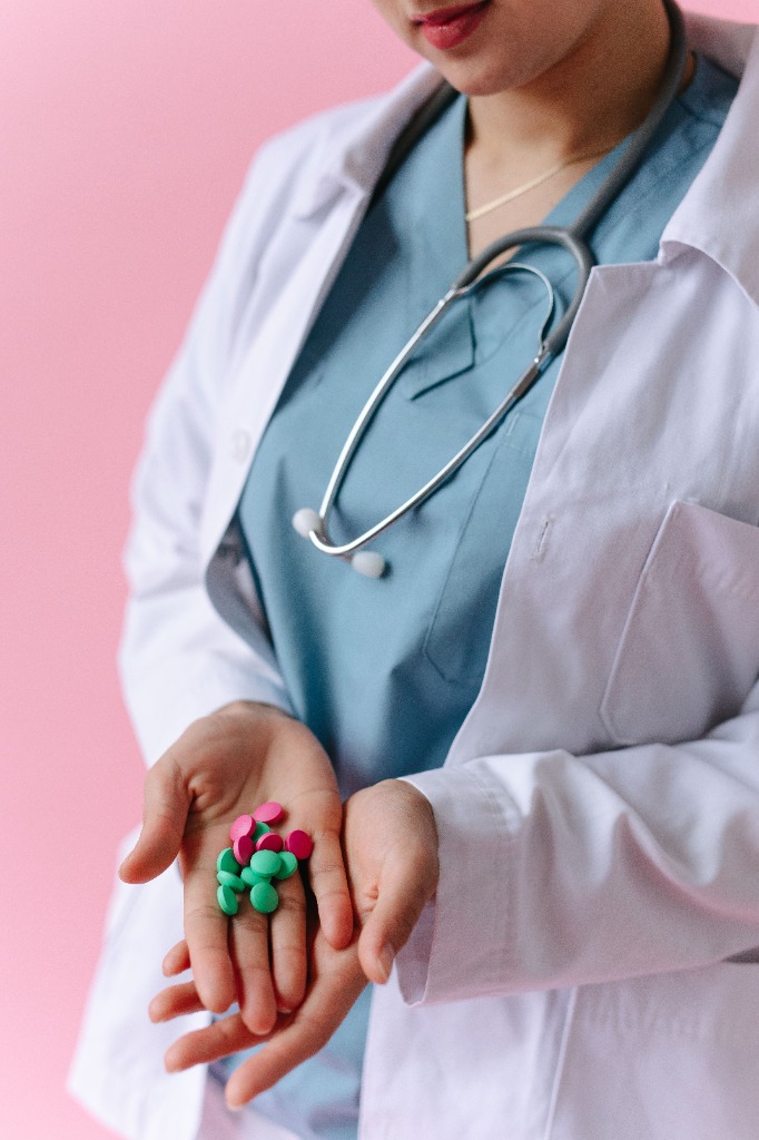 Farmacêutica segurando comprimidos na palma da mão